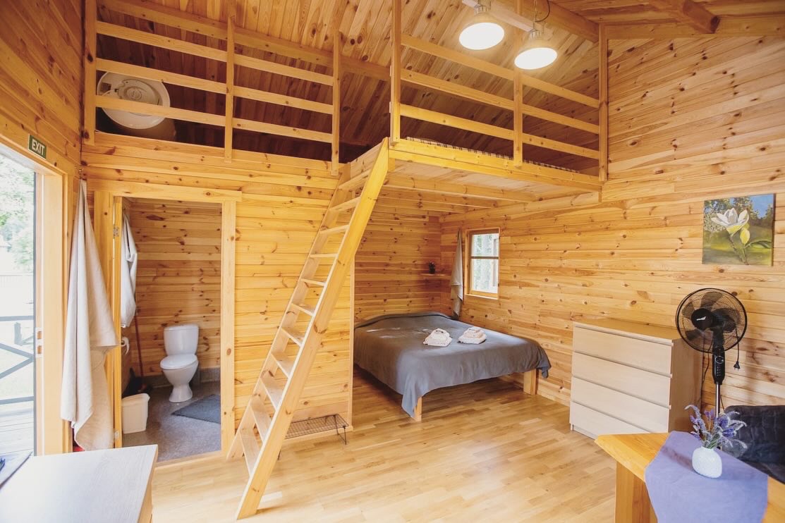 Wooden cabin interior with loft and double bed